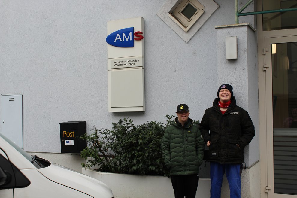 zwei Personen die vor dem AMS stehen