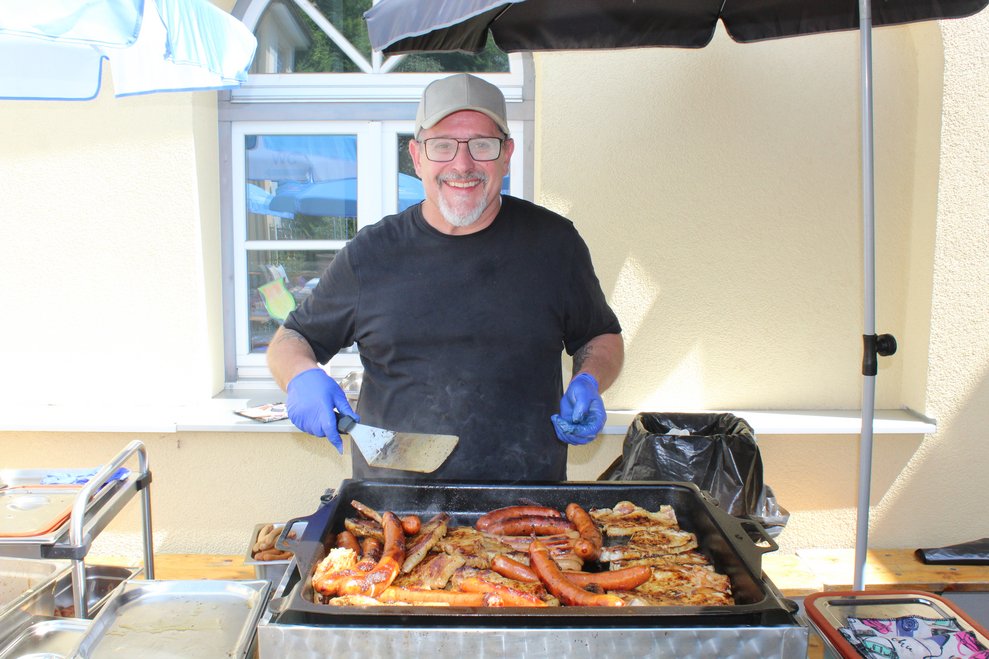 Ein Mann grillt auf einem großem Griller