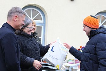 Eine Person bekommt ein Geschenk überreicht
