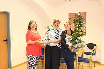 Zwei Personen überreichen ein Geschenk