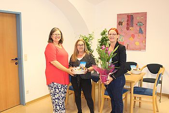 Zwei Personen überreichen ein Geschenk