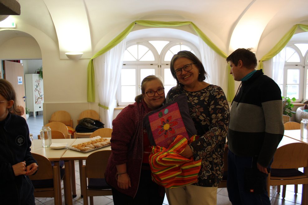 Eine Person schenkt der anderen ein Geschenk