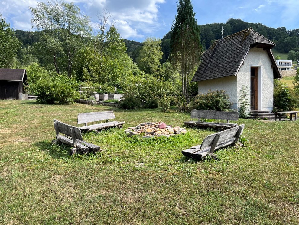 Eine Feuerstelle im Garten bestehend aus vier Holzbänken