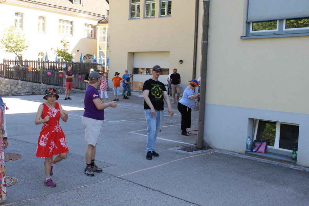 Mehrere Personen stehen draußen und spielen Spiele.