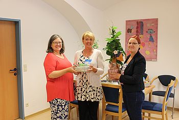 Zwei Personen überreichen ein Geschenk