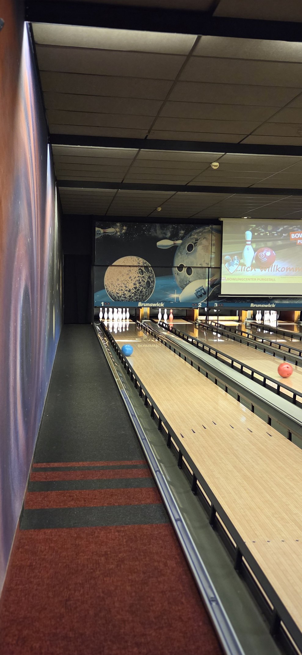 Eine Kugel rollt die Bowlingbahn hinunter