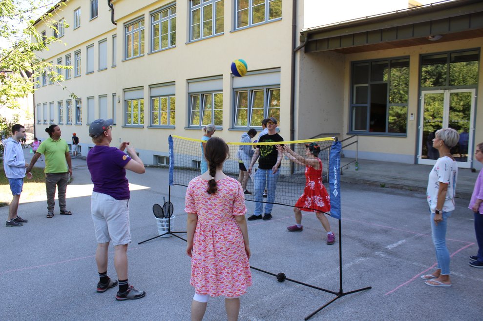 Einige Personen spielen Volleyball.