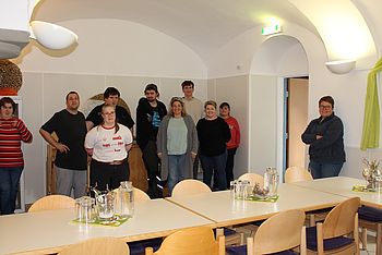Eine Gruppe Personen stehen in einem Raum