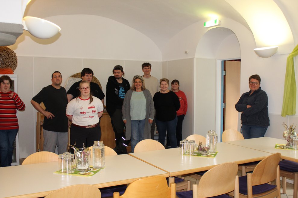 Eine Gruppe Personen stehen in einem Raum