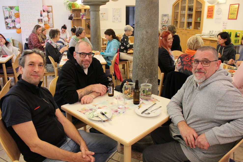 Drei Männer sitzen an eine Tisch
