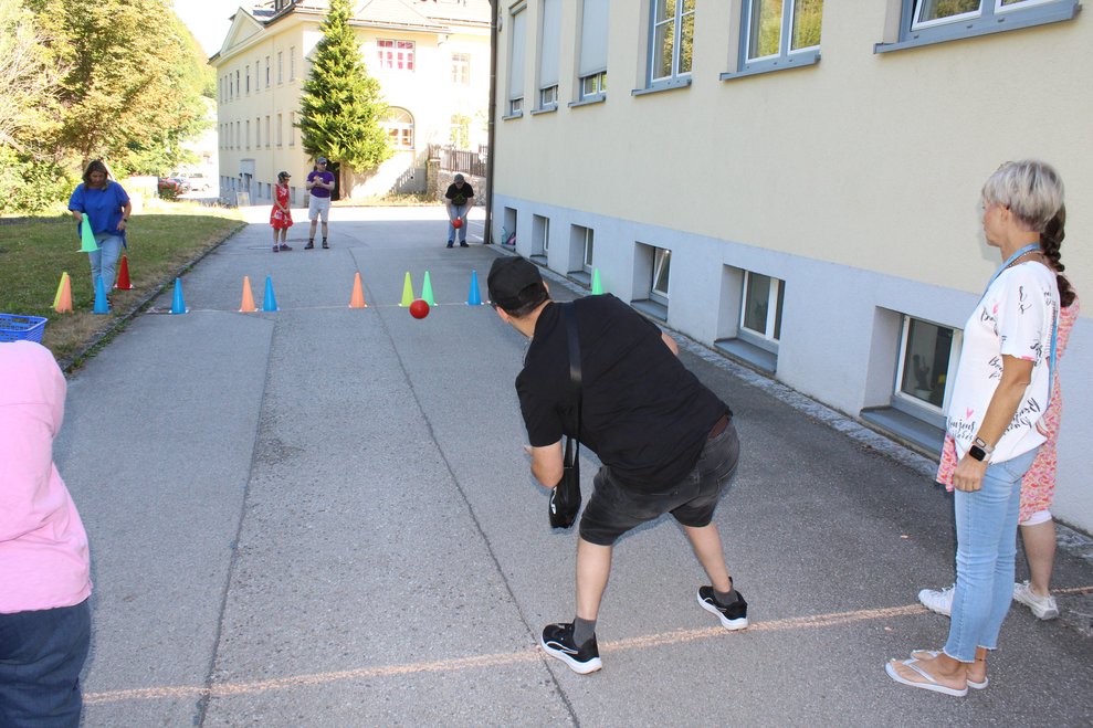 Ein junger Mann trifft die Kegel beim Kegel Spiel.