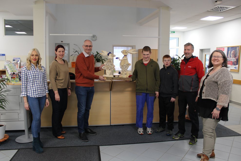 mehrere Personen mit einem Osterhasen aus Holz