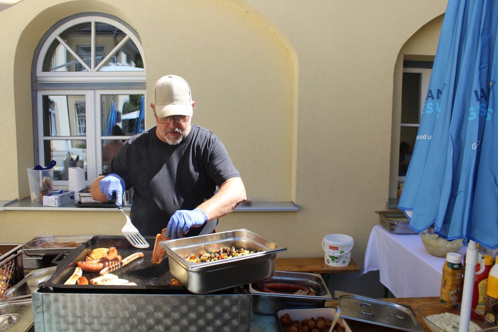 Ein Mann grillt auf der Terrasse.