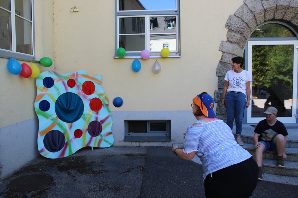 Eine Dame wirft den Ball ins Loch.