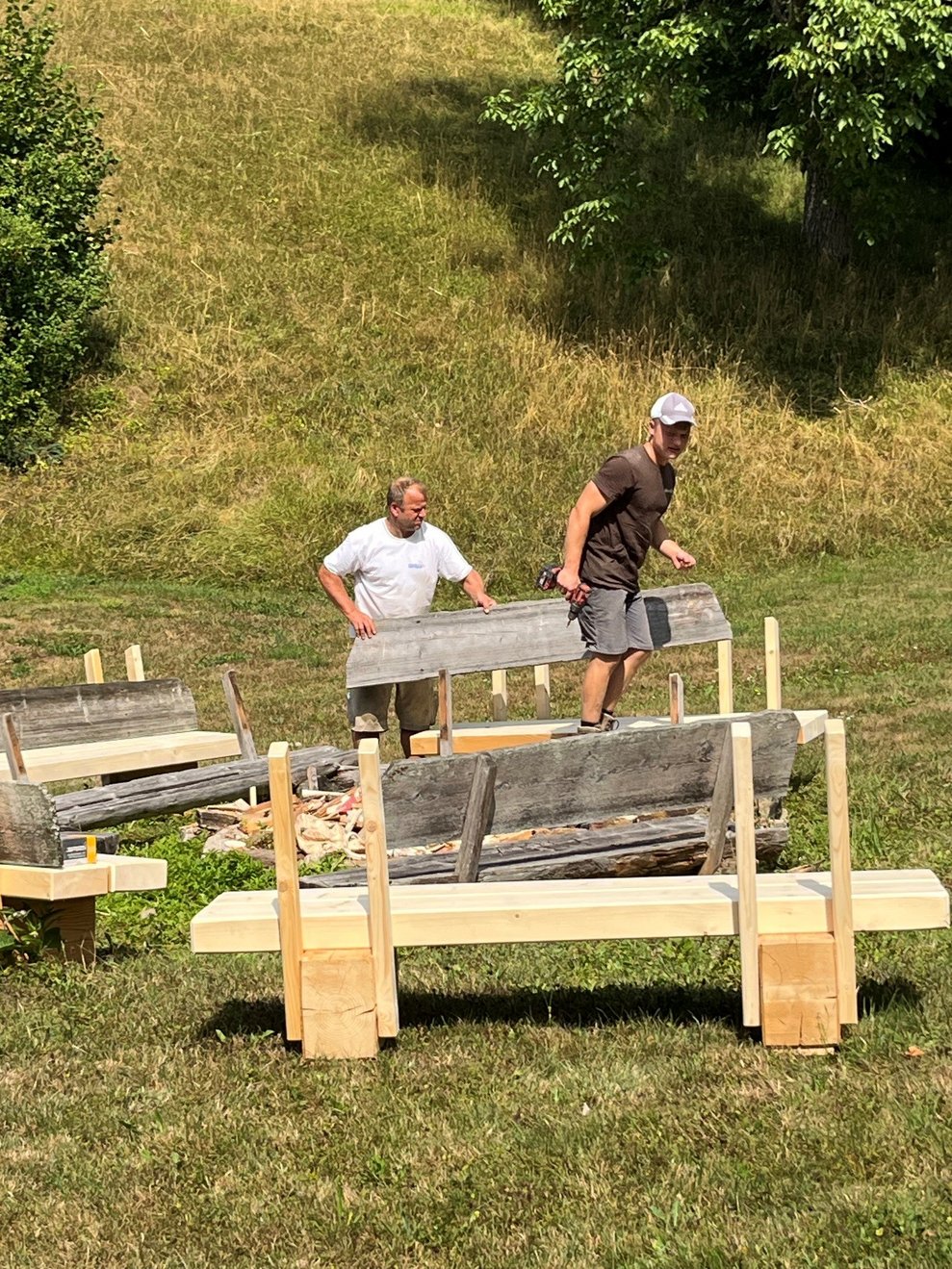 Die Arbeiter stellen die Holzbänke auf.
