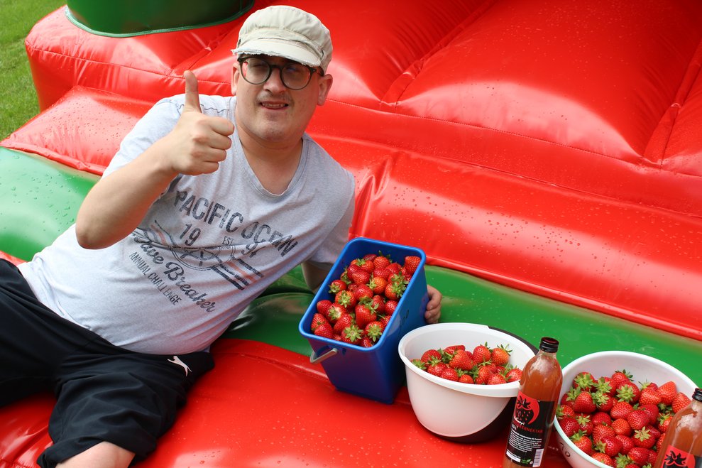 Eine Person mit vielen Erdbeeren.