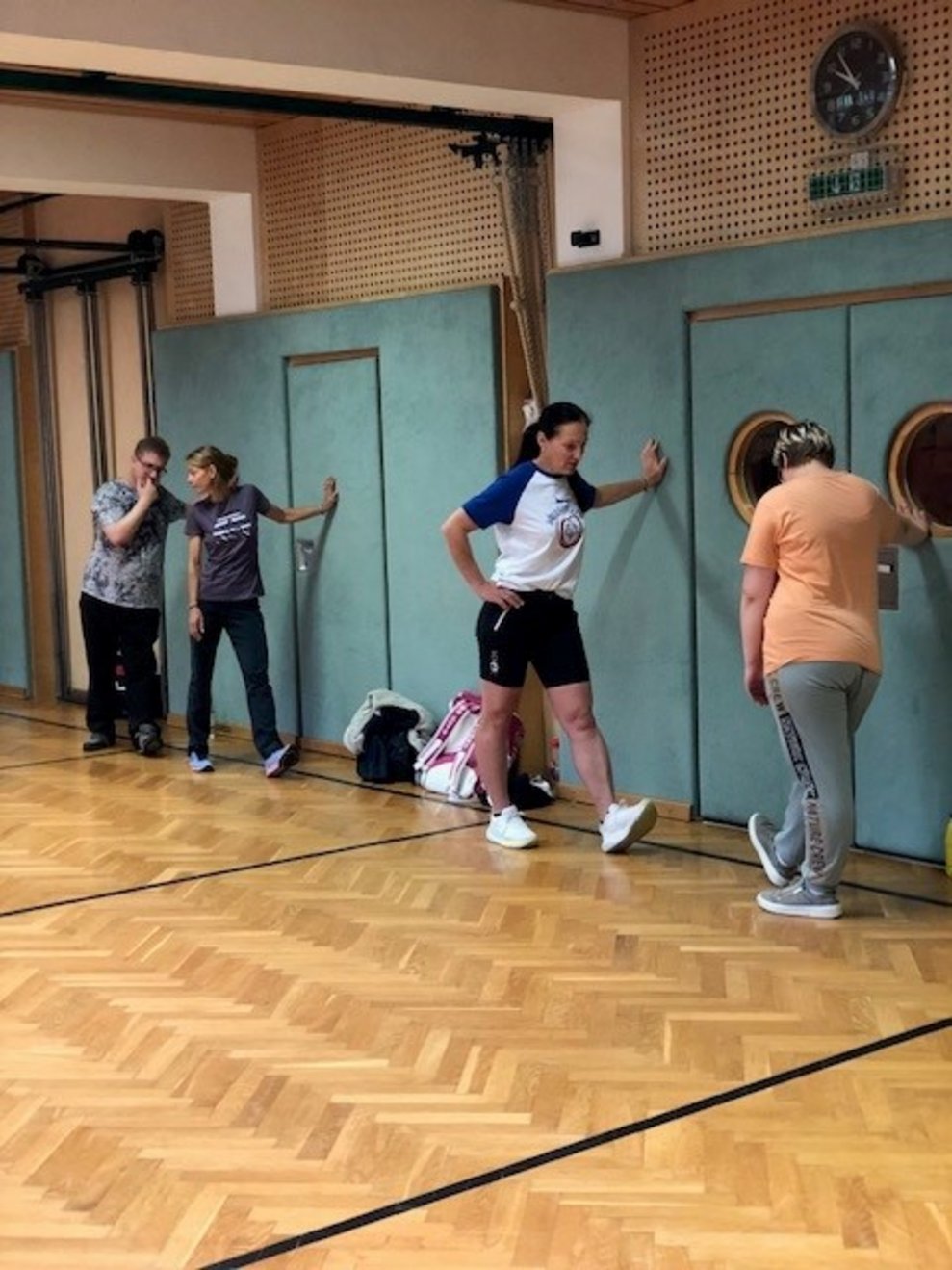 Vier Personen machen Sport Übungen in einer Turnhalle