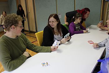 Mehrere Personen spielen ein Kartenspiel