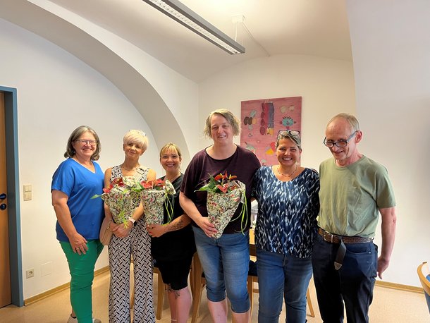 Fünf Damen und ein Herr stehen für ein Foto zusammen.