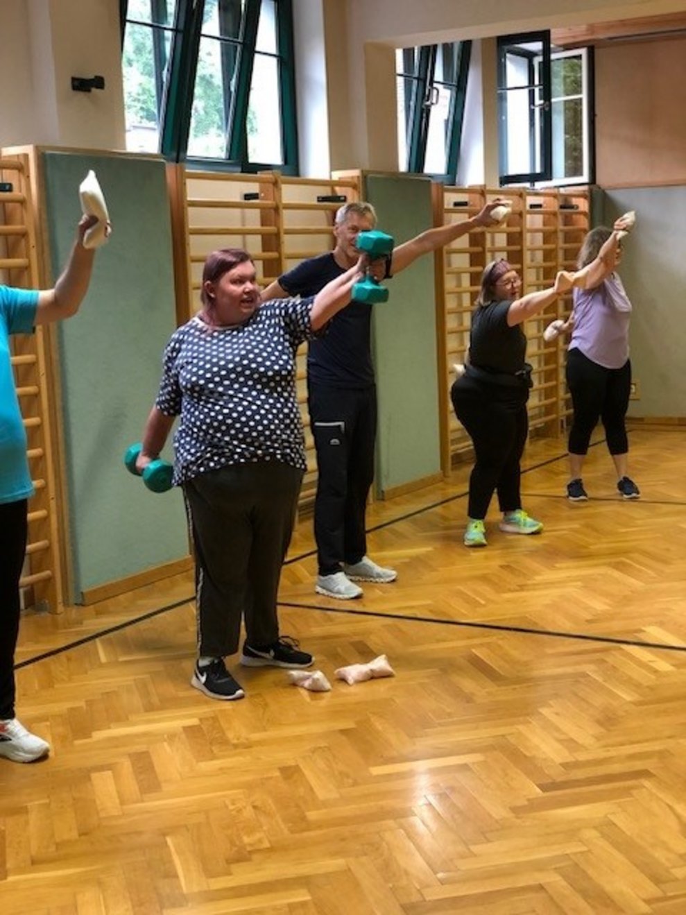 Personen die gemeinsam in einer Turnhalle Sport machen