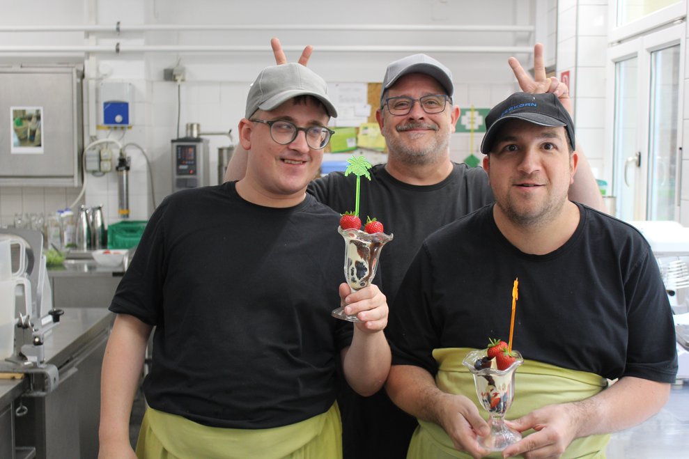 3 Personen mit einem Erdbeer-Dessert.