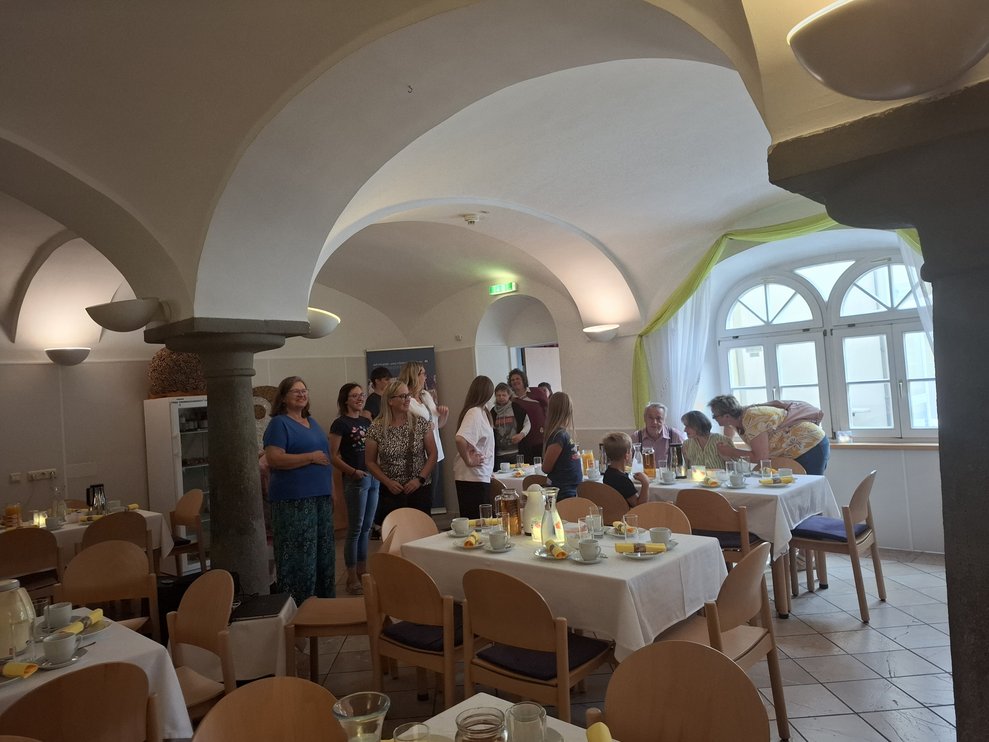 Ein großer Saal in dem Personen stehen.