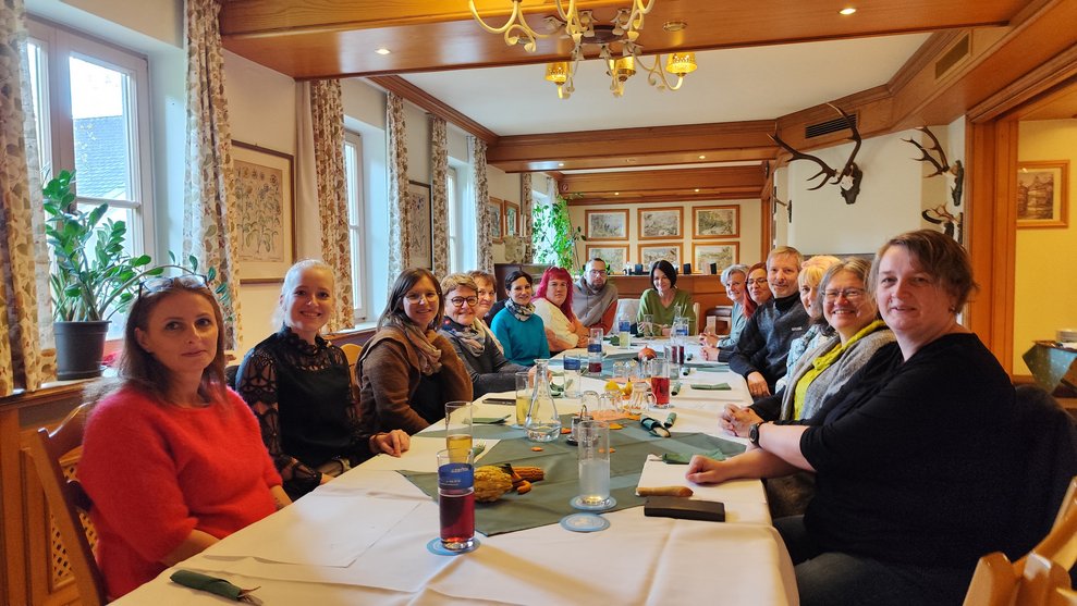Eine Gruppe Personen sitzt an einem großen Tisch.