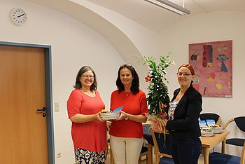Zwei Personen überreichen ein Geschenk