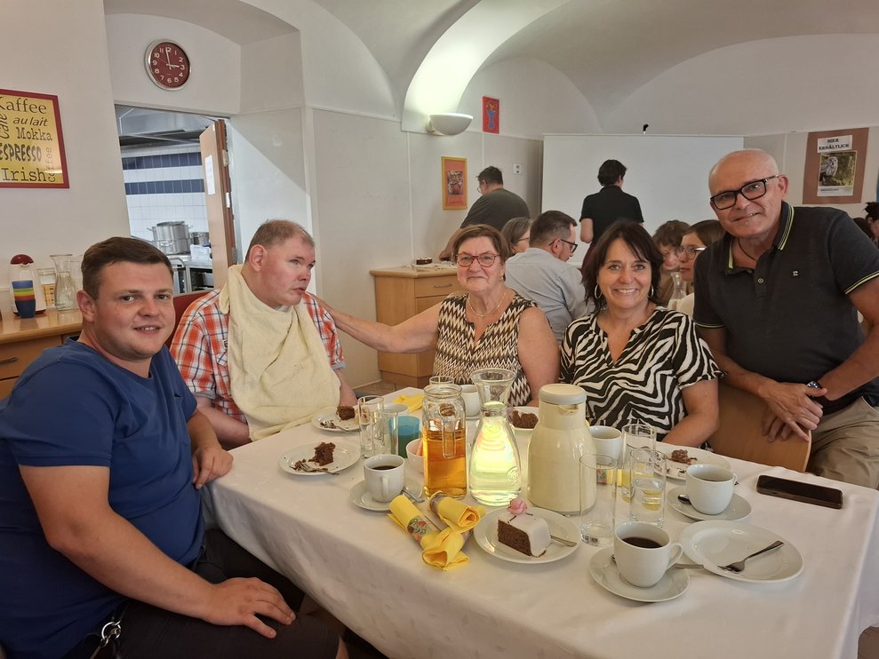 Drei Männer und zwei Damen sitzen bei eine Tisch