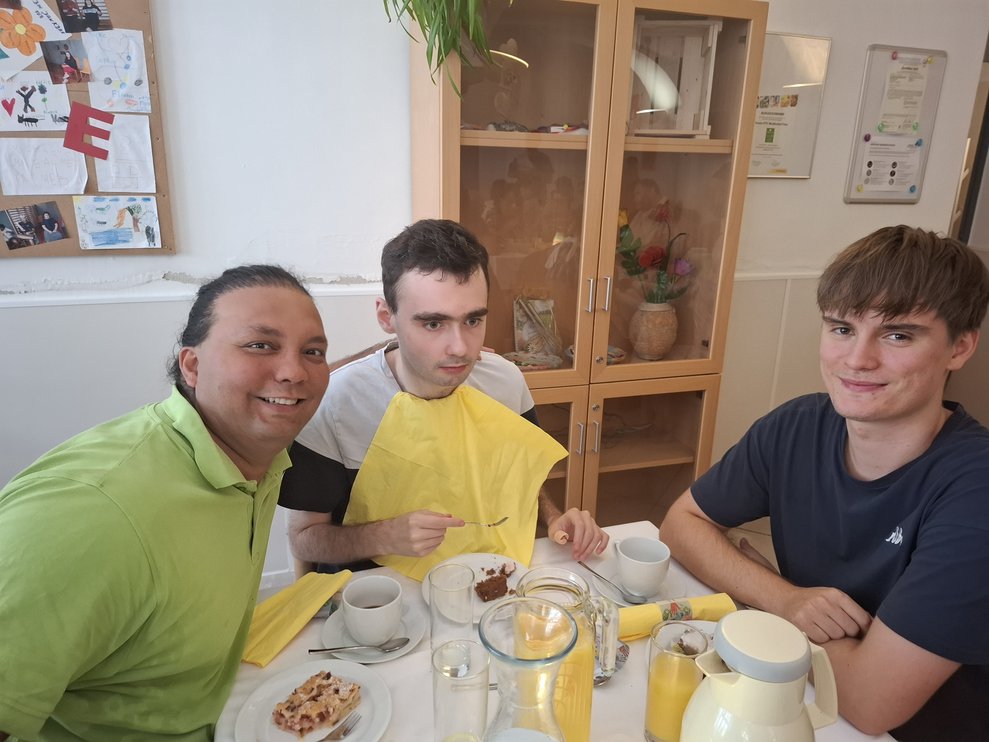 Drei Männer sitzen bei einem Tisch